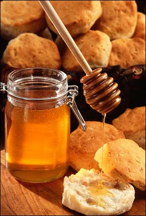 Honey pouring on fresh biscuits